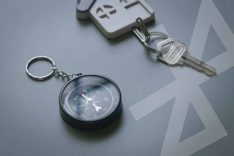 Selective-Focus-Of-Compass-And-Key-Holder-With-Key-On-A-Gray-Background-Bluetooth-Key-Finder